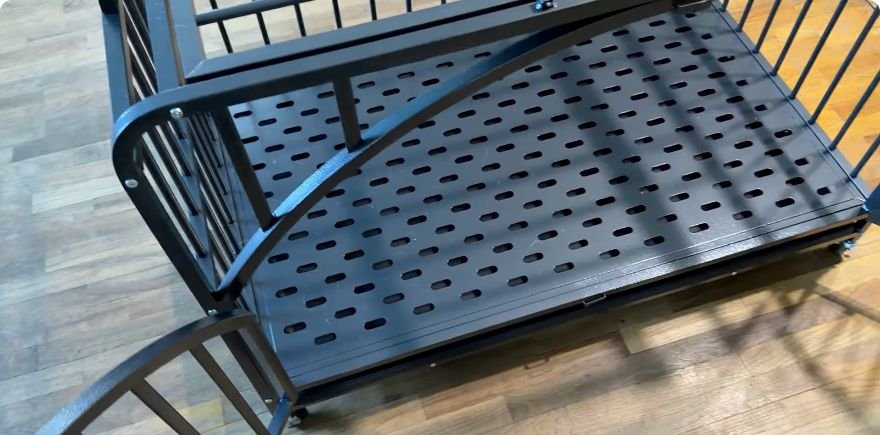 Close-up of the perforated metal floor and open French doors on the dog crate