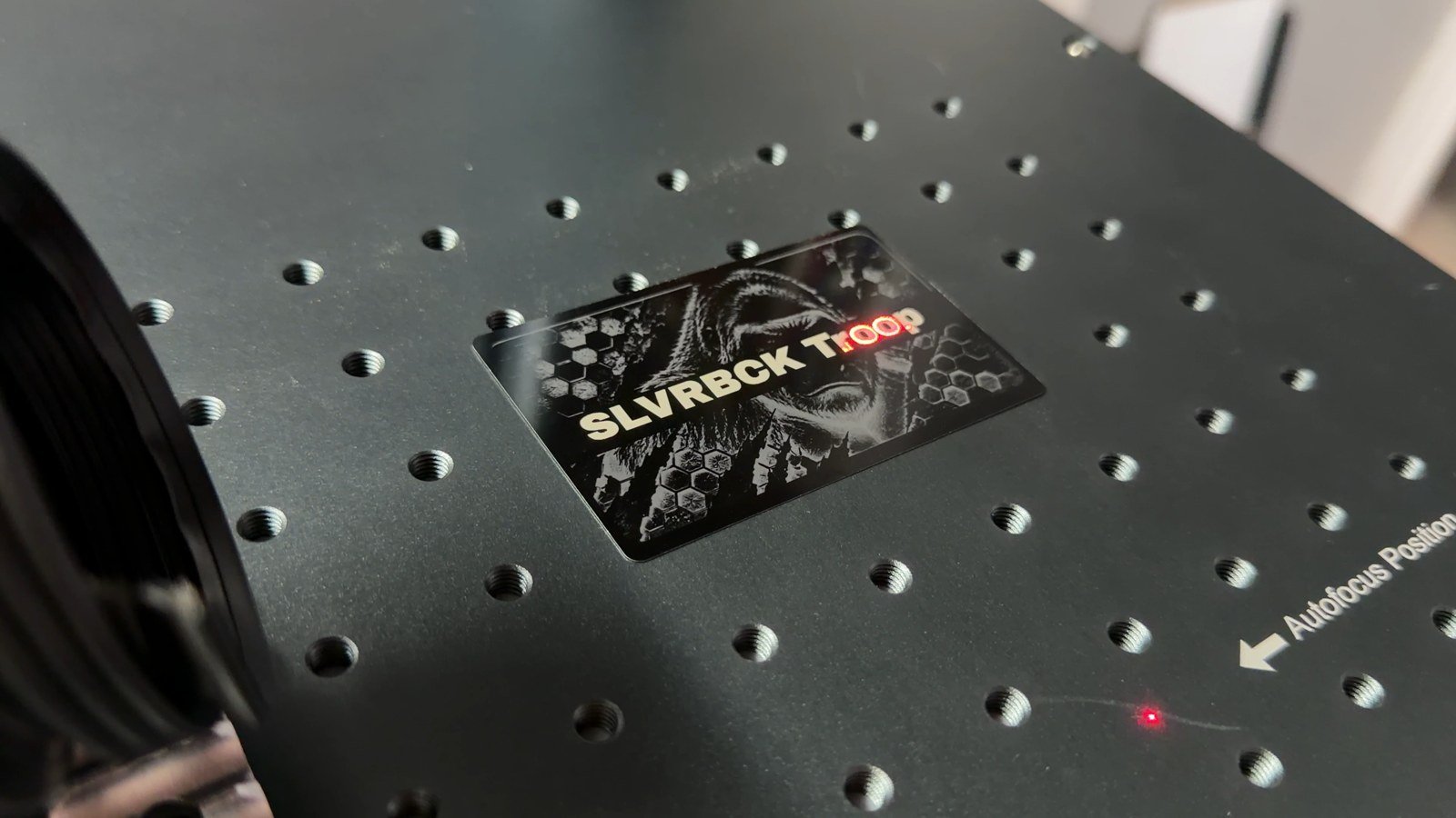 SLVRBCK Troop design engraved on an anodized aluminum card on the Monport workbench